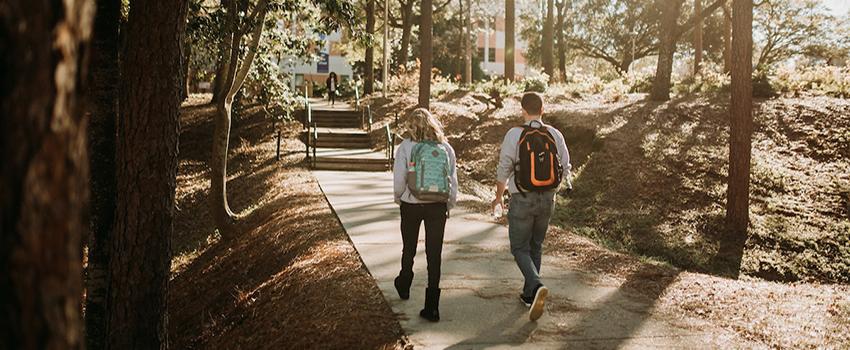 Two students walking toward the arts and sciences building.