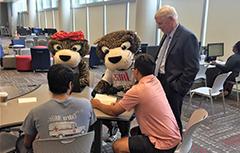 Dr. Waldrop, Southpaw, and Miss Pawla with USA students at a table working